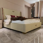 Light Beige Upholstered Bed with Quilted Texture, Natural Wood Veneer Trim & Metal Emblem Accents